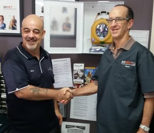 Mick Hughes shaking hands with Albany Creek Veterinary Surgery representative after providing Defibrillator Training Equipment