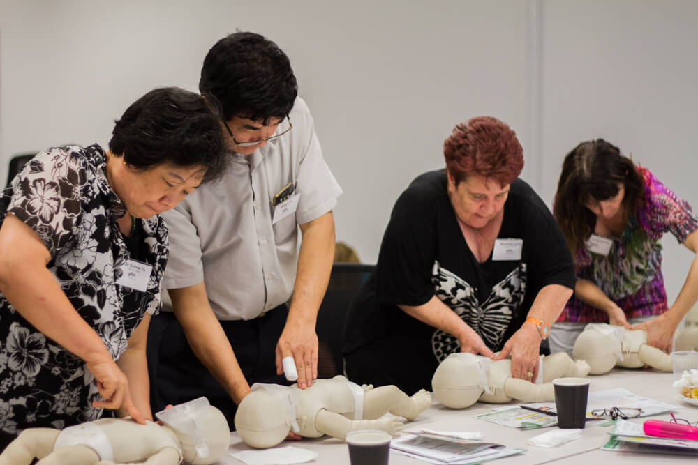 Practicing infant CPR techniques using mannequins at Primary Healthcare South, under the guidance of BLS First Aid.