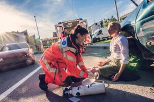 Female doctor providing first aid to woman injured in car accident.